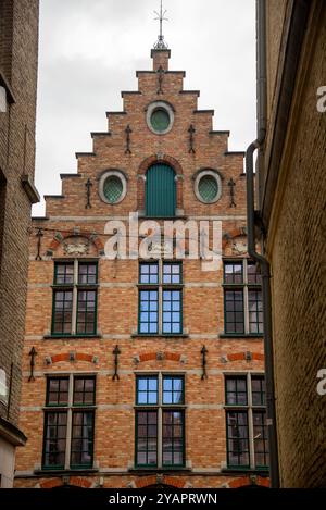 Traditioneller Ziegelstein corbie Stufengiebel und Steinpfosten in Westflandern, Brügge, Belgien. Stockfoto