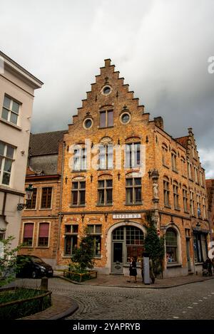 Traditioneller Stufengiebel, oculus-Fenster und Eckskulptur in Brügge, Belgien. Stockfoto