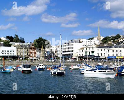 Eine Ansammlung kleiner Boote, die im Innenhafen von Torquay vertäut sind, dahinter befindet sich ein denkmalgeschützter Uhrenturm, der 1902 als Denkmal für Torquay erbaut wurde Stockfoto
