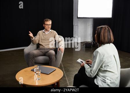 Ein Journalist engagiert einen Spezialisten in einem professionellen Interview in einem Studio zu einer durchdachten Diskussion. Stockfoto