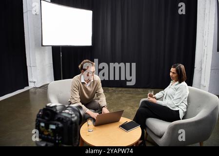 Eine Journalistin mittleren Alters engagiert sich in einem durchdachten Interview mit einem Spezialisten, in dem ihr Fachwissen vorgestellt wird. Stockfoto