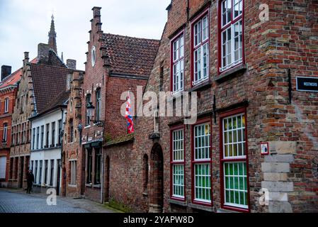 Gotischer Turm der Kirche unserer Lieben Frau und Ziegelsteingiebel in Brügge, Belgien. Stockfoto