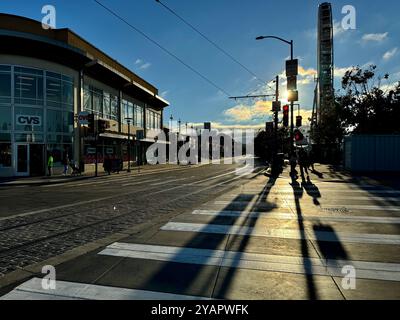 Stimmungsvoller Blick auf den Sonnenuntergang auf die Fußgängerüberquerung in Embarcadero und Jefferson mit dem Sky Star Riesenrad. Stockfoto