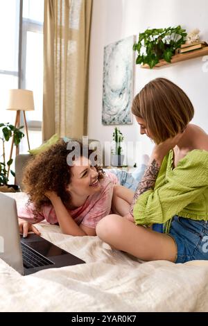 Ein fröhliches junges Paar lacht, während es sich auf dem Bett entspannt, umgeben von Grün. Stockfoto