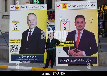 Duhok, Irak. Oktober 2024. Der Kurdische Mann steht neben den Wahlbändern der Kandidaten der Kurdischen Demokratischen Partei (KDP/PDK) vor den Wahlen zum Kurdischen Regionalparlament in Duhok, Irak. (Foto: Ismael Adnan/SOPA Images/SIPA USA) Credit: SIPA USA/Alamy Live News Stockfoto