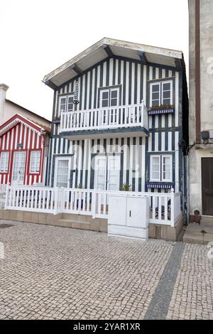 Portugiesische Touristenstraße mit ihren emblematischen gestreiften und farbenfrohen Häusern. Ende des Tages. Costa Nova do Prado, Aveiro, Portugal - August 2024 Stockfoto