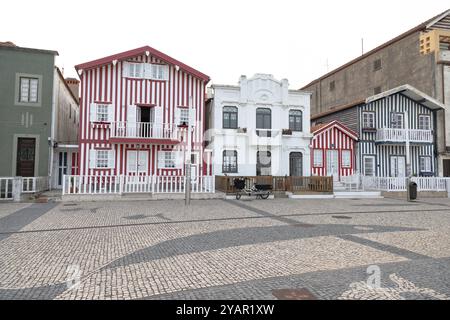 Portugiesische Touristenstraße mit ihren emblematischen gestreiften und farbenfrohen Häusern. Ende des Tages. Costa Nova do Prado, Aveiro, Portugal - August 2024 Stockfoto