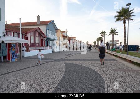 Costa Nova do Prado, Aveiro, Portugal - 30. August 2024 - portugiesische Touristenstraße mit ihren emblematischen gestreiften und bunten Häusern. Ende des Tages. Stockfoto