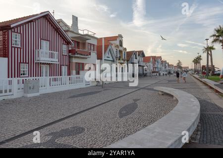 Costa Nova do Prado, Aveiro, Portugal - 30. August 2024 - portugiesische Touristenstraße mit ihren emblematischen gestreiften und bunten Häusern. Ende des Tages. Stockfoto