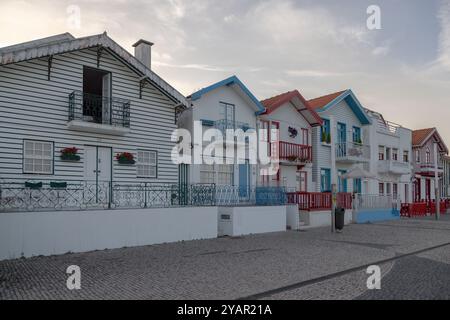 Portugiesische Touristenstraße mit ihren emblematischen gestreiften und farbenfrohen Häusern. Ende des Tages. Costa Nova do Prado, Aveiro, Portugal - August 2024 Stockfoto