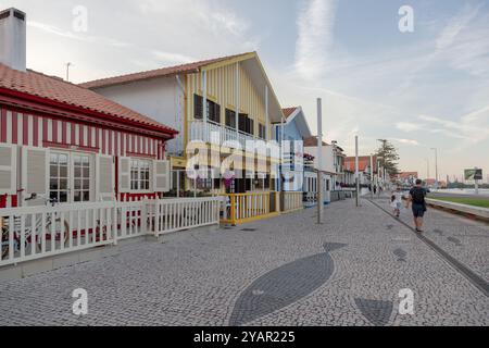 Costa Nova do Prado, Aveiro, Portugal - 30. August 2024 - portugiesische Touristenstraße mit ihren emblematischen gestreiften und bunten Häusern. Ende des Tages. Stockfoto