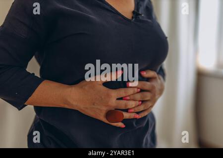 Eine Frau legt ihre Hände auf den Bauch und führt externe Techniken als Teil der chiropraktischen Zwerchfellatmung durch. Hochwertige Fotos Stockfoto