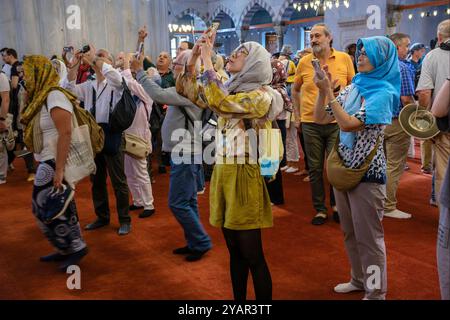 Touristen fotografieren in der Blauen Moschee, Istanbul, Türkei Stockfoto