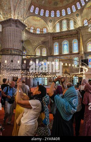 Touristen fotografieren in der Blauen Moschee, Istanbul, Türkei Stockfoto