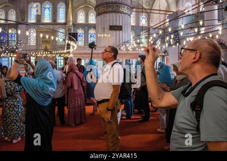 Touristen fotografieren in der Blauen Moschee, Istanbul, Türkei Stockfoto