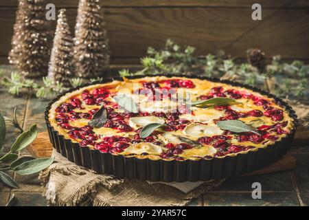 Cranberry Ziegenkäse-Tarte mit Salbei auf rustikalem blauen Hintergrund Stockfoto