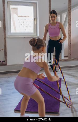 GymnasGymnast Kind führt eine Übung mit Reifen. Professionelle Sportarten für Kinder. t Kind führt eine Übung mit einem Ring aus. Kinderprofi spor Stockfoto