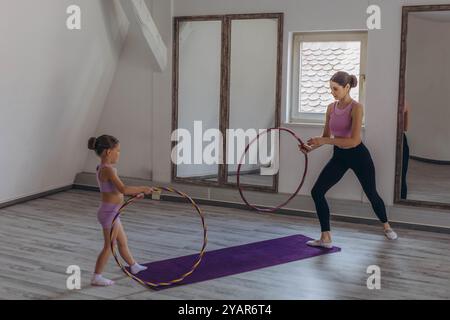 GymnasGymnast Kind führt eine Übung mit Reifen. Professionelle Sportarten für Kinder. t Kind führt eine Übung mit einem Ring aus. Kinderprofi spor Stockfoto