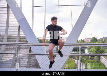 latein-Mann sitzt nach dem Training und schaut sich die Smart Watch an, um die Herzfrequenz zu überprüfen Stockfoto