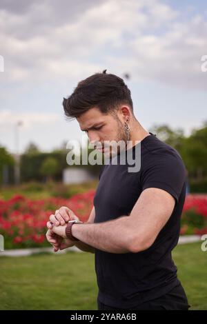 Sportlicher Mann, der die Herzfrequenz mit seiner intelligenten Uhr misst Stockfoto