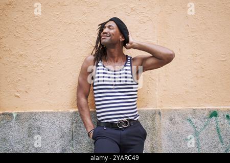 Porträt eines afroamerikanischen Mannes mit Dreadlocks, die auf einer gelben Wand posieren Stockfoto