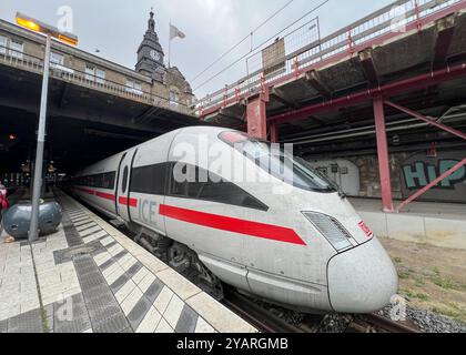 Symbolbild ICE am Gleis im Hamburger Hauptbahnhof, rote Linie und DB-Logo sichtbar, historisches Bahnhofsgebäude im Hintergrund, Uhr und architektonische Details erkennbar, moderne Bahnsteigbeleuchtung, Kontrast zwischen Alter Bausubstanz und moderner Technologie, symbolisiert Hochgeschwindigkeitsverkehr und Mobilität, Verbindung von Vergangenheit und Gegenwart, zentraler Verkehrsknotenpunkt in Hamburg, wichtige Rolle der Deutschen Bahn im Fernverkehr *** Symbolbild EIS auf der Strecke am Hamburger Hauptbahnhof, rote Linie und DB-Logo sichtbar, historisches Bahnhofsgebäude im Hintergrund, Uhr Stockfoto