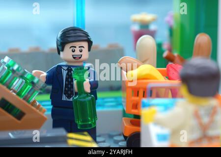 Tambow, Russische Föderation - 15. Oktober 2024 Eine Minifigur eines Lego-Geschäftsmannes, die in einem Supermarkt ein Getränk in Flaschen kauft. Stockfoto