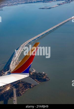 San Francisco, Kalifornien - Ein Flugzeug der Southwest Airlines fliegt über Yerba Buena Island und die San Francisco-Oakland Bay Bridge. Stockfoto