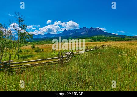 Alpenwiese mit Zaun und Blick auf die Mount Sneffels Range im Hintergrund. Stockfoto