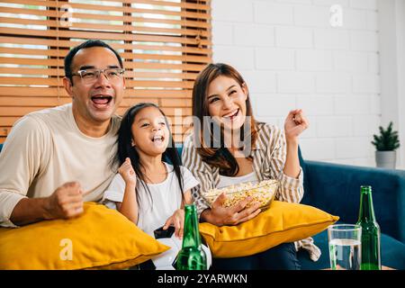 Eine glückliche Familie genießt den Nervenkitzel eines Fußballspiels zu Hause Stockfoto