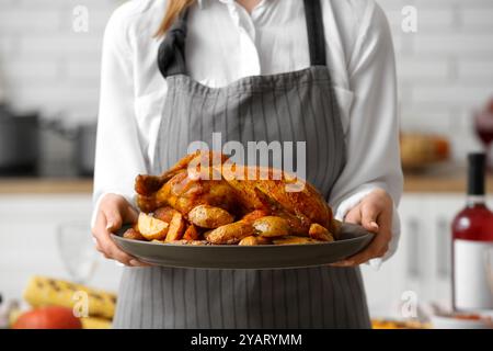 Frau mit leckerem truthahn zum Thanksgiving-Tag in der Küche, Nahaufnahme Stockfoto