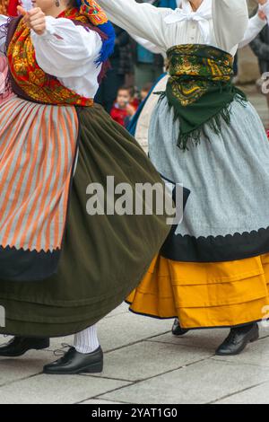 Frauen, die in der traditionellen Tracht Galiciens gekleidet sind, tanzen zu populärer Musik, Folklore-Party Stockfoto