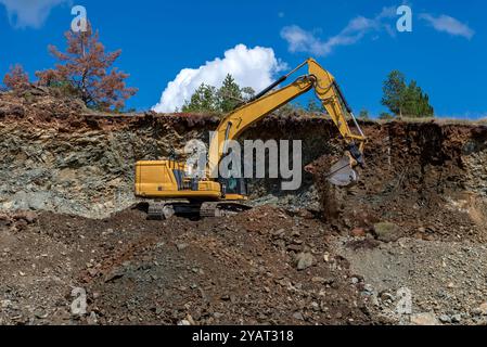 Ein Bagger arbeitet an einem sonnigen Tag auf einer Baustelle. Stockfoto