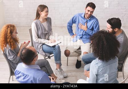 Fröhlicher Mann schätzt die Unterstützung der Menschen am rehab Group Meeting Stockfoto