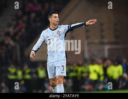 . Schottland gegen Portugal UEFA Nations League: League A, Gruppe 1 15. Oktober 2024 Hampden Park, Glasgow. Schottland . Cristiano Ronaldo (Portugal) sieht aus, wie Sicherheitsleute einen Fan auffangen, der während des Schottland-Spiels auf dem Spielfeld einmarschierte. Credit: eric mccowat/Alamy Live News Stockfoto