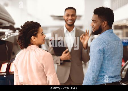 Afroamerikanisches Paar Beratung Mit Verkäufer Kauf Auto In Showroom Stockfoto
