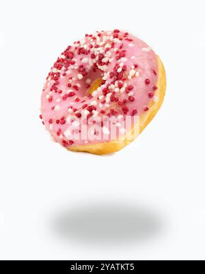 Fliegender Donut aus rosafarbener Schokolade und mehrfarbigen Streuseln mit isoliertem weißem Hintergrund Stockfoto