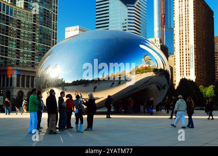 Eine Menschenmenge versammelt sich um Cloud Gate, besser bekannt als The Bean, zieht Besucher des Millennium Park in Chicago an Stockfoto