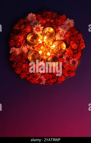 Diwali-Feier. Diya-Lampen und wunderschöne Blumen auf farbigem Hintergrund, Blick von oben. Leerzeichen für Text Stockfoto