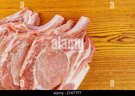 Mehrere rohe Schweinefleisch-Steaks werden in einer Reihe angeordnet, die zum Marinieren bereit sind Stockfoto