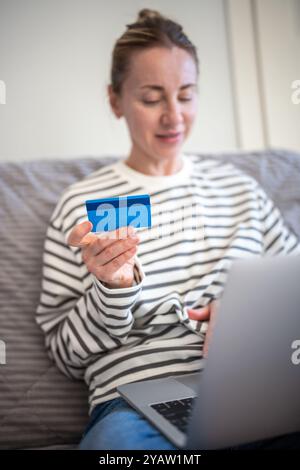 Bequemes Online-Shopping von zu Hause aus mit Laptop bezahlt Internet-Einkäufe mit Kreditkarte Stockfoto