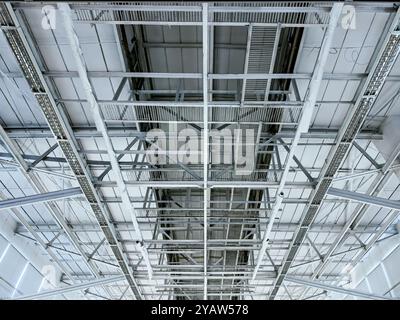 Dach eines großen Industriegebäudes mit Stahlträgerkonstruktion. Innenansicht von unten. Stockfoto