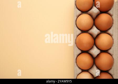 Hühnereier in einem offenen Eierkarton auf Beige. Naturgesunde Ernährung und ökologischer Landbau. Stockfoto