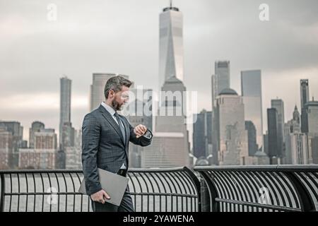 Geschäftsmann, der darauf achtet, Zeit für die Organisation von Unternehmen zu verwalten. Geschäftsmann mit Laptop in New York City. Financial Manhattan. Büro Stockfoto