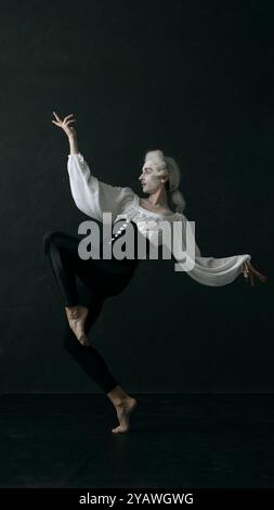 Künstlerische, edle Balletttänzerin, die in Bewegung vor Vintage-Hintergrund tanzt. Klassische Schönheit. Stockfoto