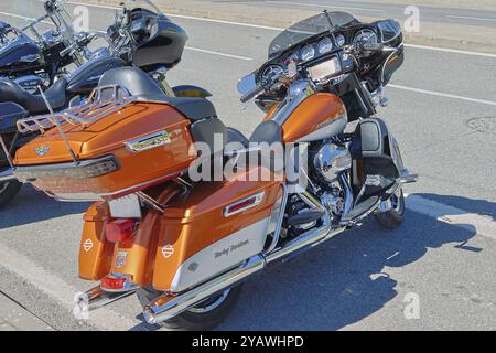 Das individuell gestaltete harley davidson electra Glide Motorrad in Orange und weiß steht auf einer Asphaltstraße Stockfoto