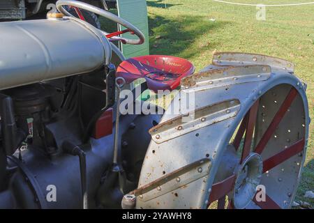 Nahaufnahme eines alten ferguson-Traktors, der den Sitz und das große Metallrad zeigt und die Geschichte und Technologie der Landwirtschaft veranschaulicht Stockfoto