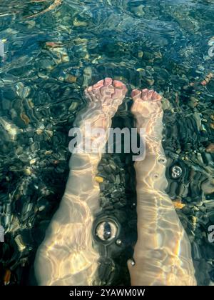 Die Füße der kaukasischen Frau im Wasser Stockfoto