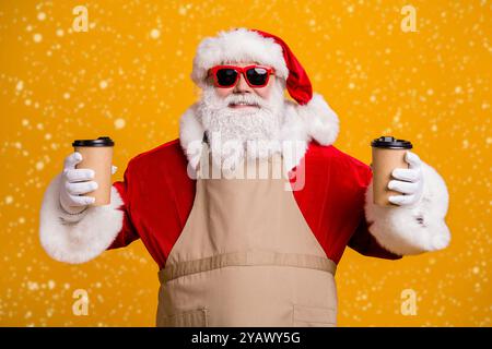 Nahaufnahme Porträt von seinem schönen attraktiven fröhlichen Weihnachtsmann Der Kellner hält zwei Tassen in der Hand und bestellt Kakao Auftrag wird isoliert Stockfoto