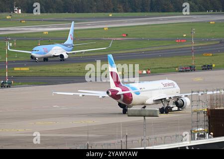 Ein Airbus von Eurowings wird zu einer Parkposition geschleppt, im Hintergrund ein Flugzeug von TUI Fly das nach der Landung zum Terminal rollt, Flughafen Düsseldorf, 15.10.2024. *** Ein Eurowings Airbus wird auf eine Parkposition gezogen, im Hintergrund fährt ein TUI Fly Flugzeug nach der Landung zum Terminal, Flughafen Düsseldorf, 15 10 2024 Stockfoto